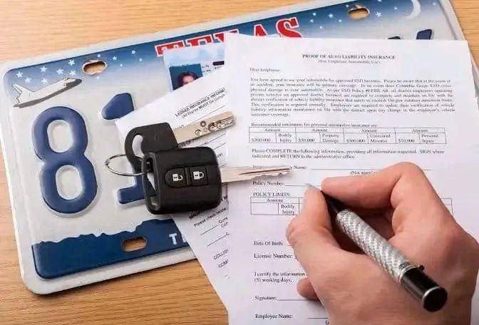 Texas license plate, car keys and vehicle paperwork on a desk